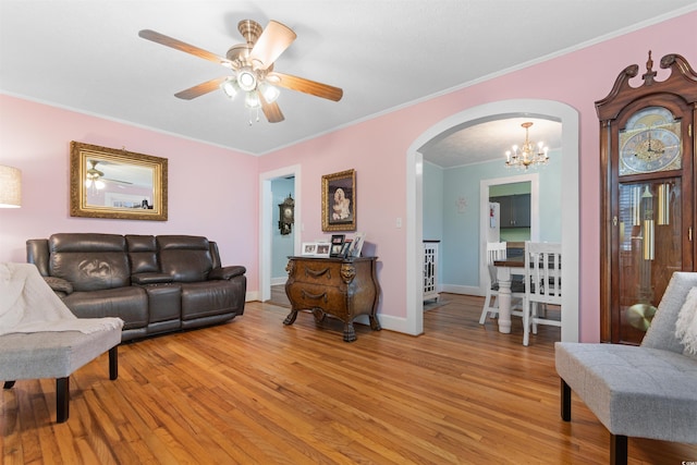 living room featuring ornamental molding, arched walkways, and light wood-type flooring