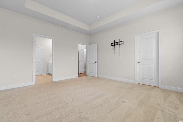 1043 Harbison Cir, Myrtle Beach, SC 29579 - unfurnished bedroom featuring light colored carpet, a raised ceiling, baseboards, and connected bathroom