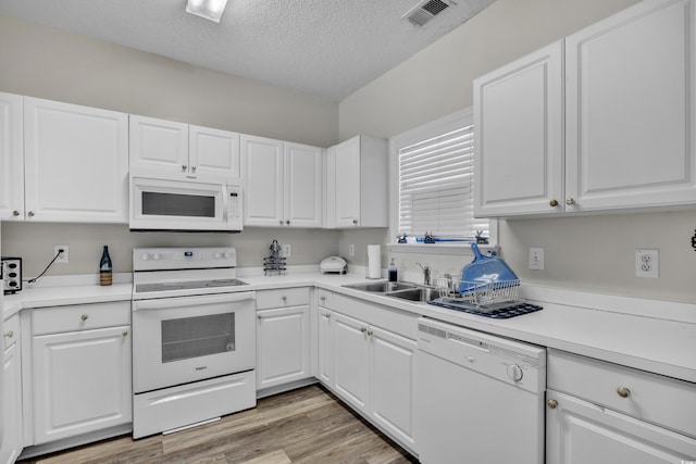 kitchen with visible vents, white appliances, light countertops, light wood-type flooring, and white cabinets