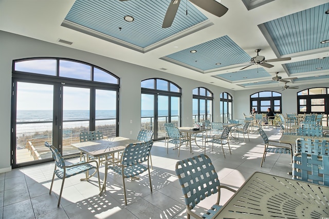 interior space with visible vents, ceiling fan, a water view, and outdoor dining area