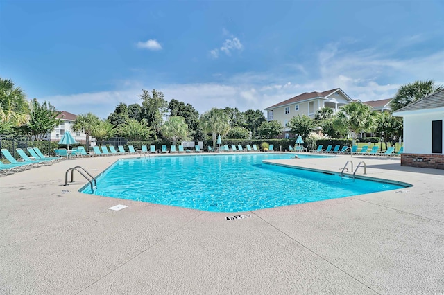 community pool featuring fence and a patio area