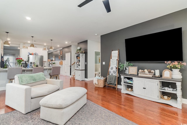 living area with light wood finished floors, ceiling fan, baseboards, and recessed lighting