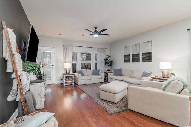 living area with dark wood finished floors, visible vents, and a ceiling fan