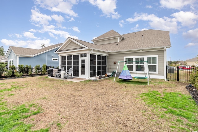 back of property featuring a patio, a shingled roof, a lawn, a sunroom, and a fenced backyard