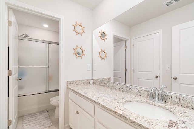 bathroom featuring toilet, shower / bath combination with glass door, visible vents, and vanity