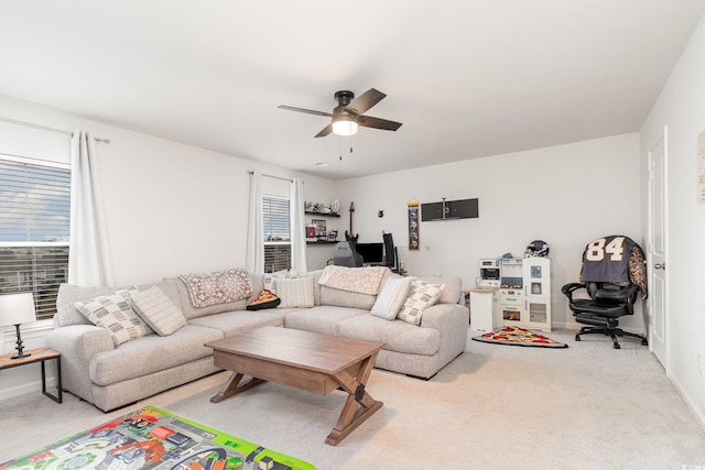 living room featuring light colored carpet, ceiling fan, and baseboards