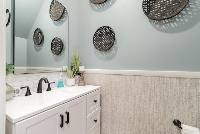 bathroom with a wainscoted wall, vanity, and tile walls