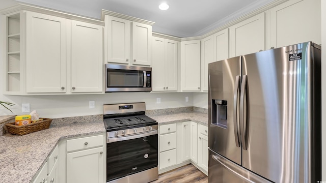 662 Sunnyside Dr Unit 101, Murrells Inlet, SC 29576 - kitchen featuring appliances with stainless steel finishes, light stone countertops, light wood-style floors, and white cabinetry