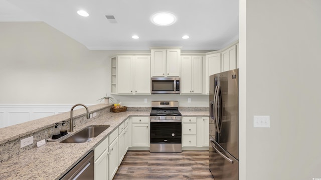662 Sunnyside Dr Unit 101, Murrells Inlet, SC 29576 - kitchen featuring appliances with stainless steel finishes, light stone counters, wood finished floors, wainscoting, and recessed lighting