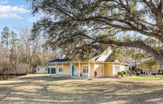 view of front of home featuring driveway, a front lawn, and covered porch