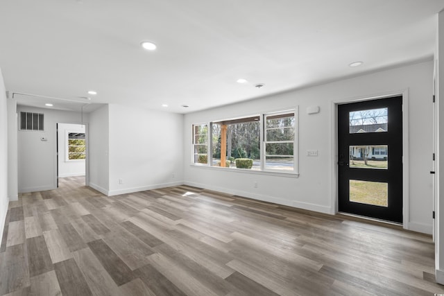 foyer entrance featuring plenty of natural light, visible vents, and light wood-style flooring