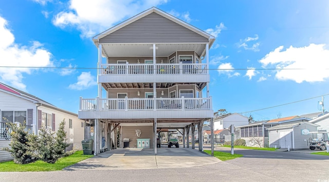 coastal home featuring driveway, a balcony, and a carport