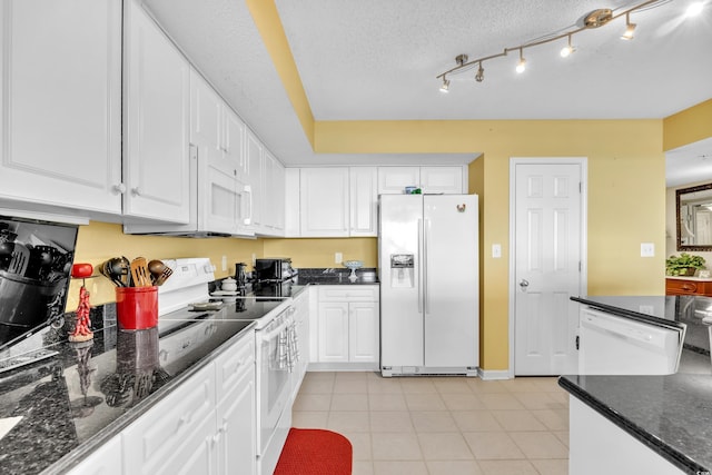 kitchen featuring white appliances, white cabinets, a textured ceiling, and light tile patterned floors