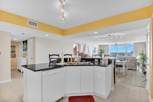 kitchen with white dishwasher, visible vents, white cabinetry, open floor plan, and dark countertops