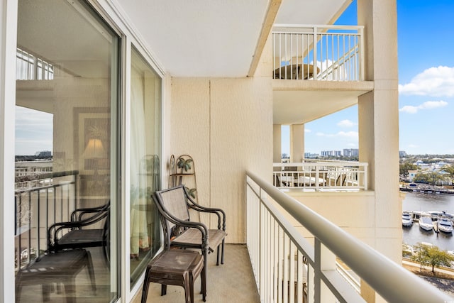 balcony with a water view and a view of city