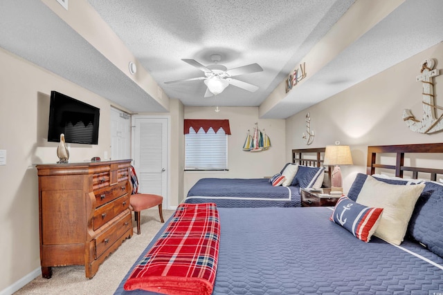 bedroom with a textured ceiling, carpet floors, a closet, and baseboards