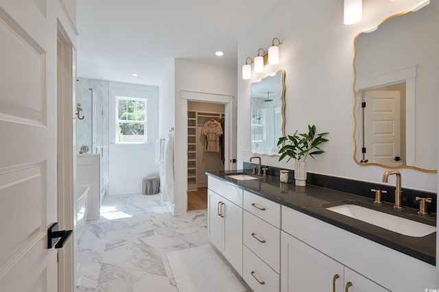 full bathroom with double vanity, marble finish floor, a shower stall, and a sink