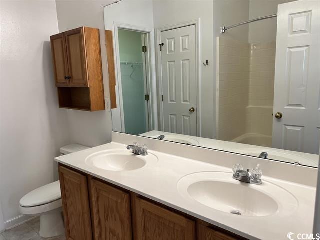 full bath with a shower, double vanity, a sink, and toilet