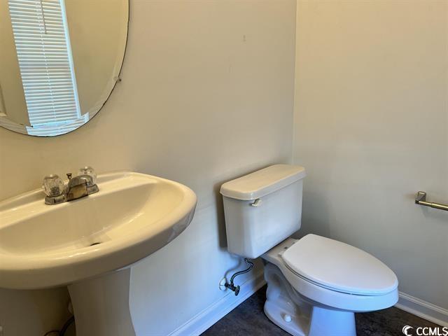 bathroom with toilet and baseboards