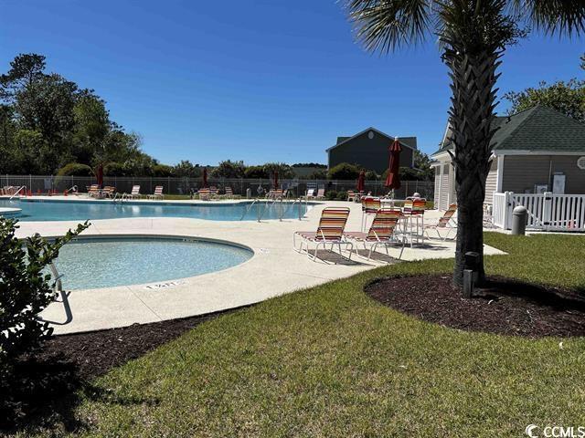 pool featuring a patio, a yard, and fence