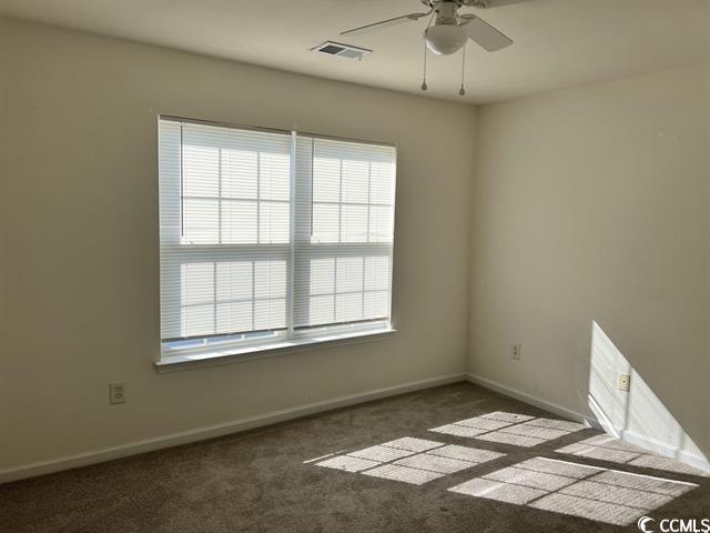 spare room with baseboards, visible vents, ceiling fan, and carpet flooring