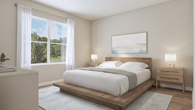 bedroom featuring baseboards and wood finished floors