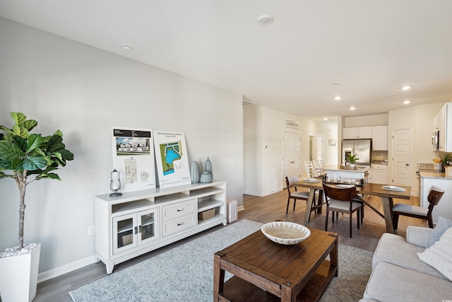 living room with dark wood-style floors, recessed lighting, and baseboards