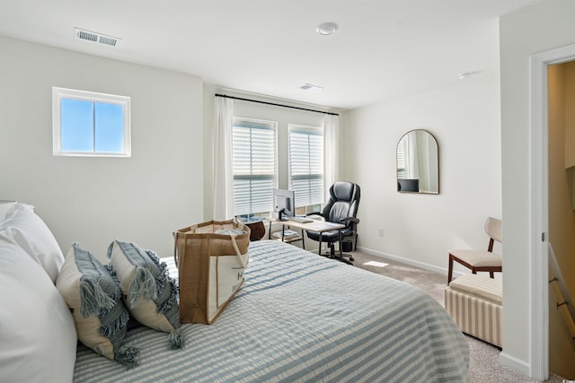 bedroom with baseboards, visible vents, and light colored carpet