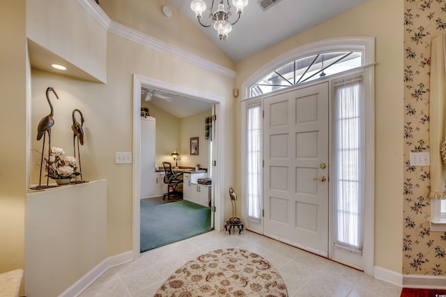 foyer entrance featuring lofted ceiling, light tile patterned floors, plenty of natural light, and a chandelier