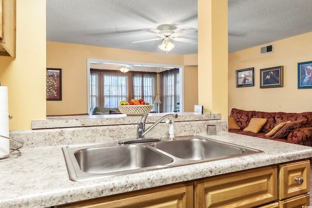 2276 Essex Dr Unit H, Surfside Beach, SC 29575 - kitchen featuring a sink, ceiling fan, light countertops, a textured ceiling, and brown cabinets