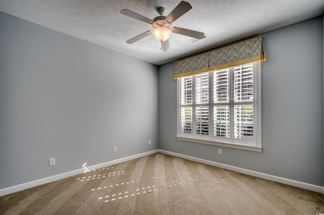 unfurnished room featuring carpet, a textured ceiling, and baseboards