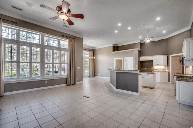 kitchen featuring light tile patterned floors, visible vents, crown molding, and ceiling fan with notable chandelier