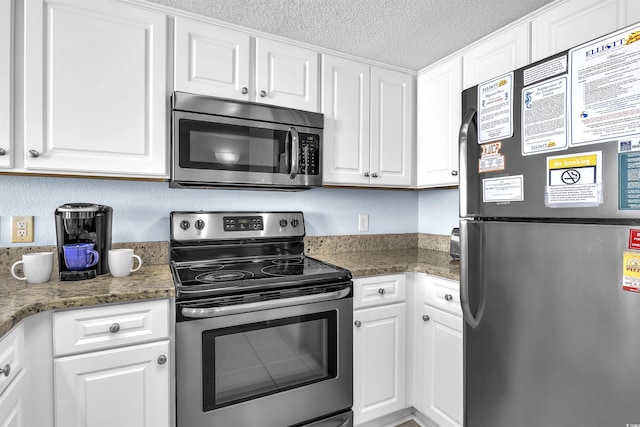 kitchen featuring white cabinets, stainless steel appliances, and a textured ceiling