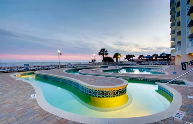 community pool with a community hot tub and a patio