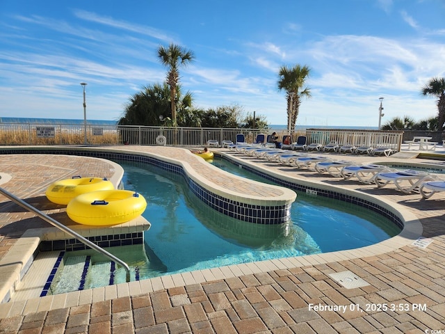 community pool featuring fence and a patio area