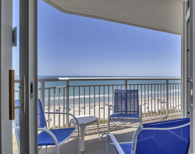 balcony featuring a beach view and a water view