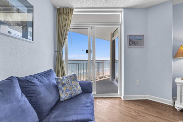 living area with baseboards, wood finished floors, and a water view