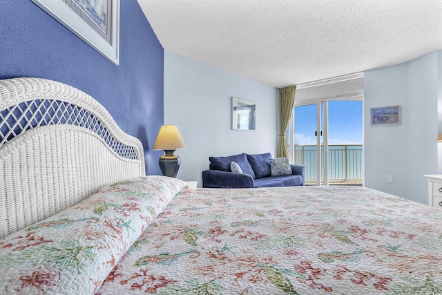 bedroom featuring access to outside and a textured ceiling