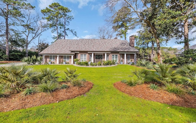 view of front of house featuring a front lawn and a chimney