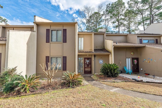 view of property with a front yard and stucco siding