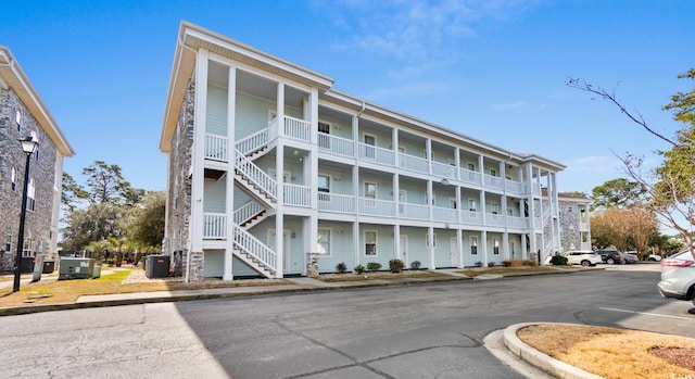 view of property featuring stairs and central AC unit