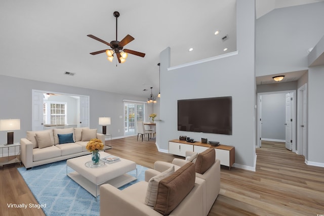 living area featuring high vaulted ceiling, baseboards, and a ceiling fan