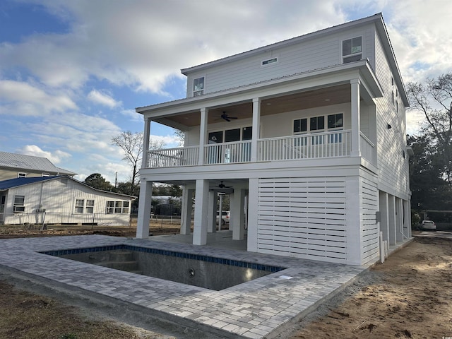 back of property featuring ceiling fan, a balcony, and a patio