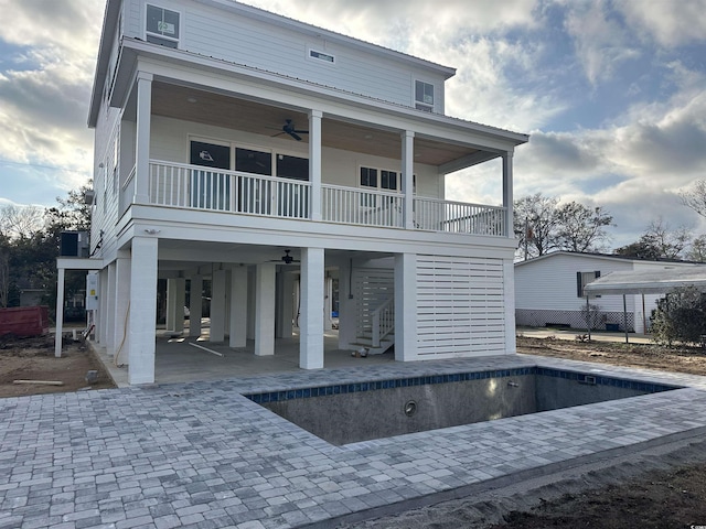 rear view of property featuring a carport, stairway, a ceiling fan, and a patio