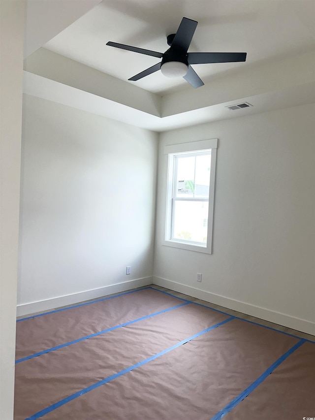 carpeted empty room featuring a ceiling fan, visible vents, and baseboards