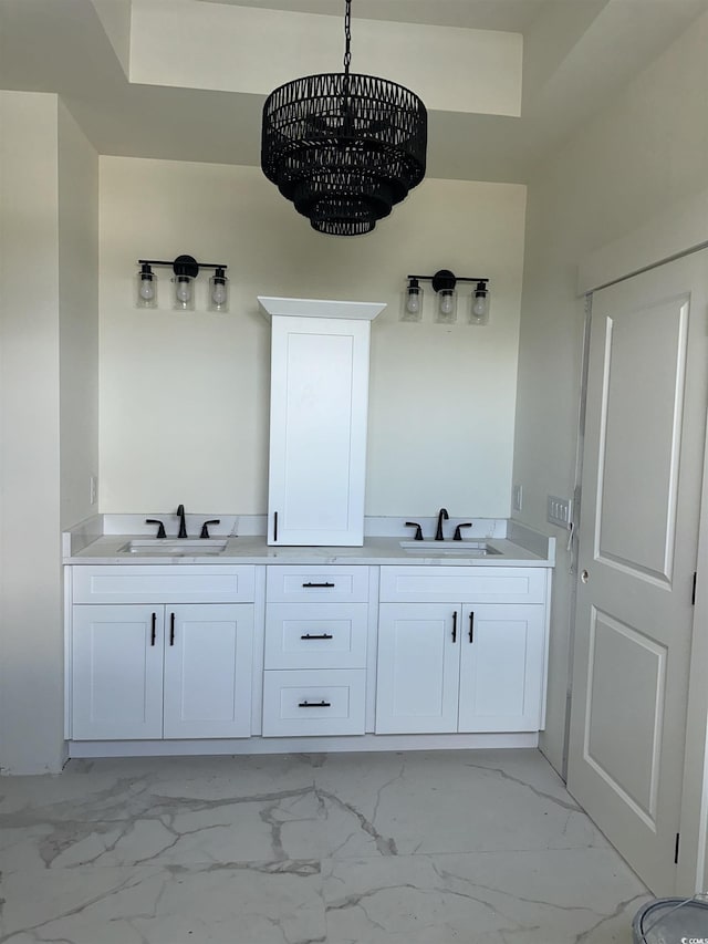 bathroom with double vanity, marble finish floor, and a sink