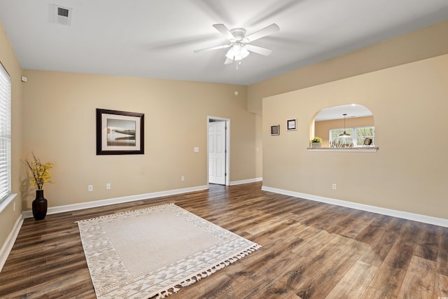 empty room featuring vaulted ceiling, ceiling fan, dark wood-style flooring, and baseboards