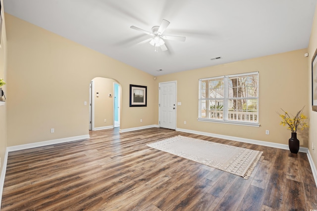 foyer entrance featuring baseboards, visible vents, arched walkways, and dark wood-type flooring