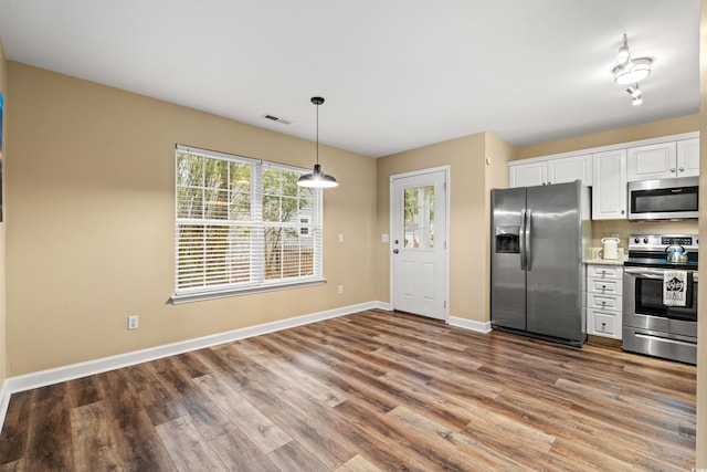 kitchen with visible vents, white cabinets, light countertops, appliances with stainless steel finishes, and pendant lighting