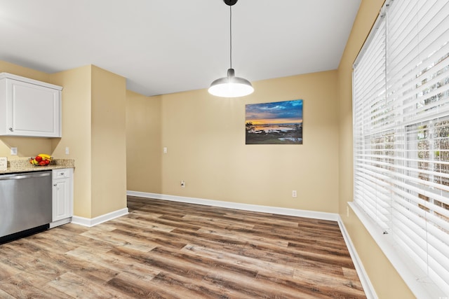 unfurnished dining area with light wood-style flooring and baseboards